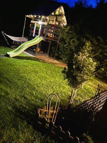a yard with a slide and a playground at night at Pokoje Gościnne Malinówka in Krościenko