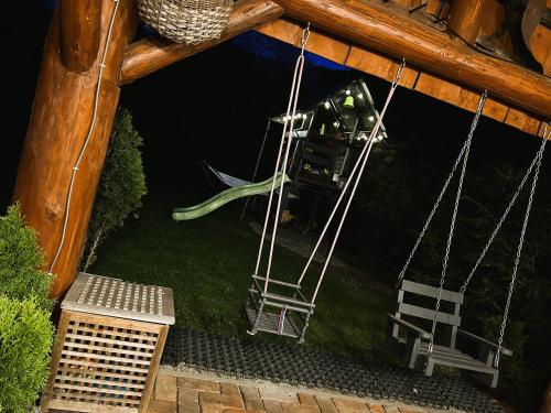 a swing in a yard with two chairs and a table at Pokoje Gościnne Malinówka in Krościenko