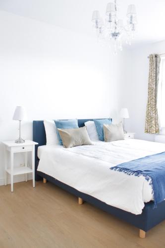 a bedroom with a large bed and a chandelier at D’oude Dune in Nieuwpoort