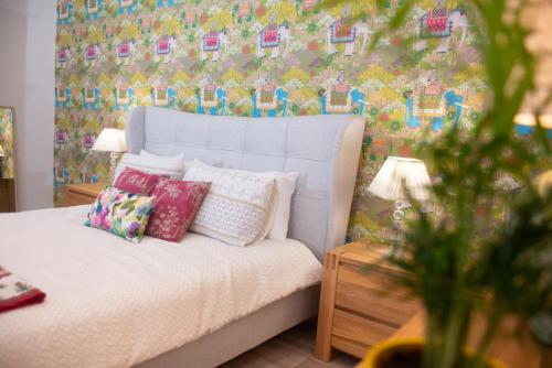 a bedroom with a white bed with a floral wallpaper at Mill Cottage Garden Studio nr Melrose in Melrose