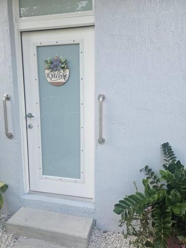 una puerta blanca con una señal en el lateral de un edificio en D&N Property Rental, en Miami