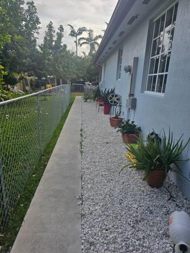 a fence next to a house with potted plants at D&N Property Rental in Miami