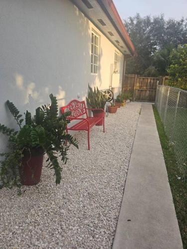 a patio with a red bench and potted plants at D&N Property Rental in Miami