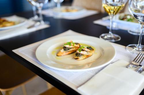 a plate of food on a table with wine glasses at Winery Rizman B&B in Slivno Ravno