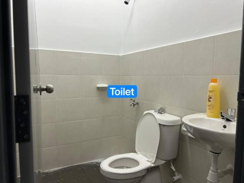 La salle de bains est pourvue de toilettes et d'un lavabo. dans l'établissement Ruma Tujoh Homestay, à Johor Bahru