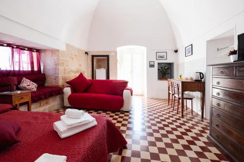 a living room with a red couch and a kitchen at CASA LAPILLI in Polignano a Mare