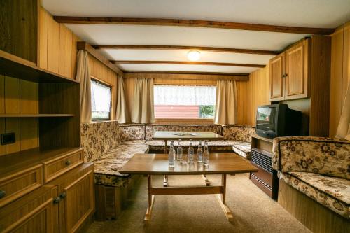 a living room with a table and a tv at Domki Letniskowe in Nielisz