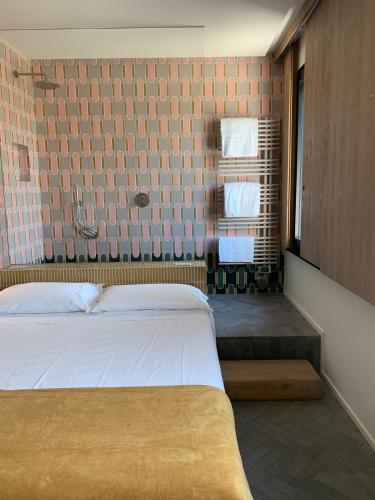 a bedroom with a bed and some towels on a shelf at OSTERIA DI CIMBRIOLO E DORMIRE AL CIMBRIOLO in Marcaria