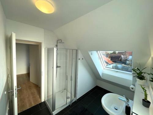 een badkamer met een glazen douche en een wastafel bij Gästehaus Stoll in Filderstadt
