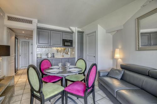 un salon avec une table, des chaises et un canapé dans l'établissement La plage privee du lac, à Duingt