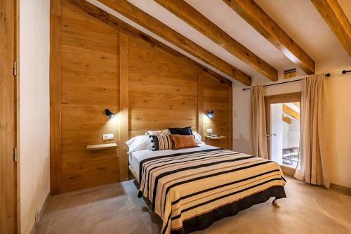 1 dormitorio con 1 cama con pared de madera en Townhouse Teluo - In the heart of Pollença, en Pollensa