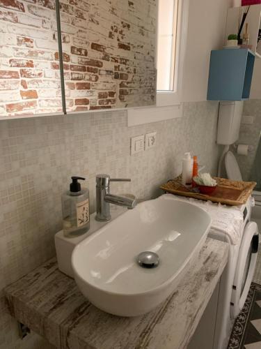 y baño con lavabo blanco y espejo. en Casina Centotrecento-Romantic & Quite Apartment-, en Bolonia