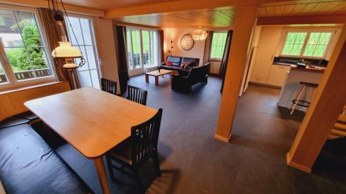 Un comedor y una sala de estar con mesa y sillas. en Chalet Catarina, en Lenk