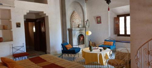 Ksar Oled Cherki的住宿－Auberge Ksar Jallal，客房设有1张床、1张桌子和1个壁炉。