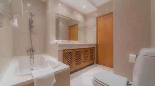 une salle de bain avec une baignoire, des toilettes et un lavabo dans l'établissement Villa Tulipa - luxury golfing resorts, à Almancil