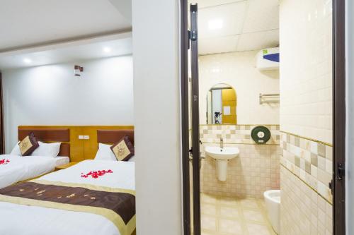 a hotel room with a bed and a bathroom at UFJ HOTEL Sầm Sơn in Sầm Sơn