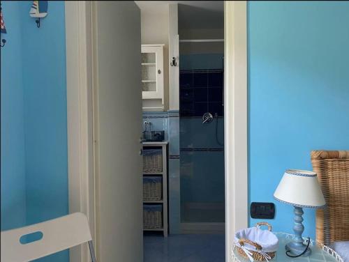 a kitchen with blue cabinets and a table with a lamp at Portovenere a due passi dal mare / parcheggio privato, ampio appartamento fino a 8 persone in Portovenere