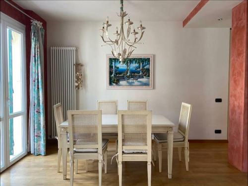 a dining room with a table with chairs and a chandelier at Portovenere a due passi dal mare / parcheggio privato, ampio appartamento fino a 8 persone in Portovenere