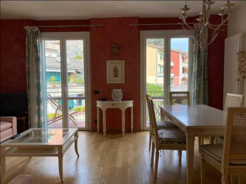 a living room with a table and a dining room with doors at Portovenere a due passi dal mare / parcheggio privato, ampio appartamento fino a 8 persone in Portovenere