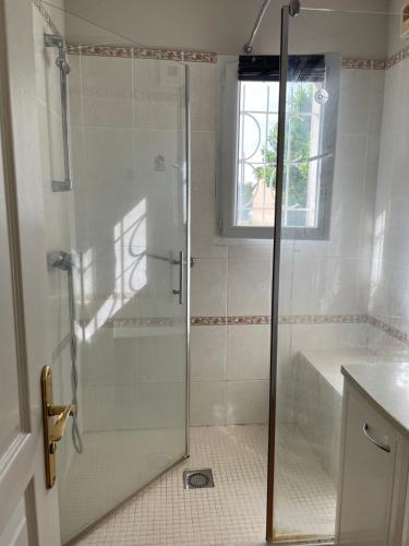 y baño con ducha y puerta de cristal. en Rochel, en Marmande