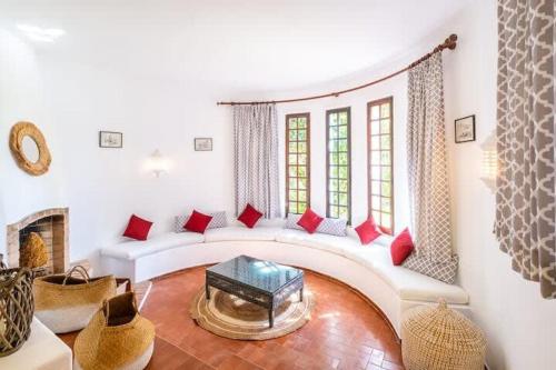 - un salon avec un canapé blanc et des oreillers rouges dans l'établissement Villa Flores - Close to the Amendoeira Golf Resort, à Pêra