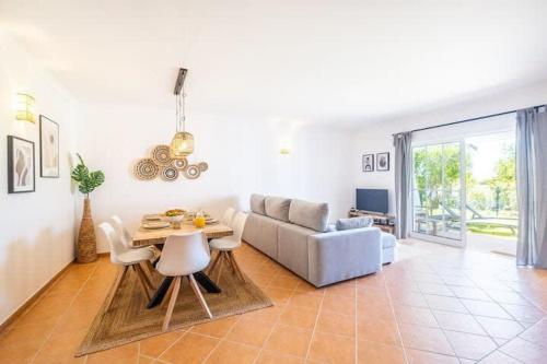 een woonkamer met een tafel en een bank bij Villa Baya - Great family complex with communal pool in Albufeira