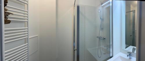 een badkamer met een douche en een glazen deur bij Majestics Luxury Apartments - 4BR 2 bath with parking - Paris Stade de France in Saint-Denis