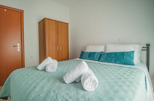 a bedroom with a bed with towels on it at Basiliki's Apartments in Archangelos