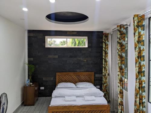 a bedroom with a bed with a black wall at Wellness Luxury Accommodation in Moshi