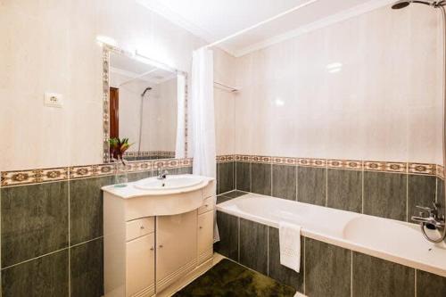 ein Badezimmer mit einer Badewanne, einem Waschbecken und einer Badewanne in der Unterkunft Apartment Marlena - complex great for families in Albufeira