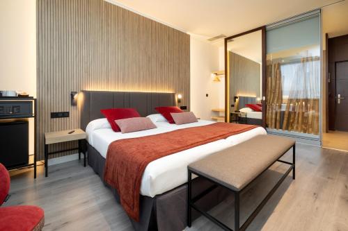 una habitación de hotel con una cama grande con almohadas rojas en Alexandre Fira Congress, en Hospitalet de Llobregat