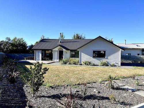 a white house with a yard in front of it at Dumblane View in Hanmer Springs