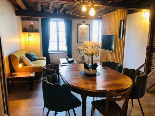 une salle à manger avec une table et des chaises en bois dans l'établissement Le Petit Meslier, à Épernay
