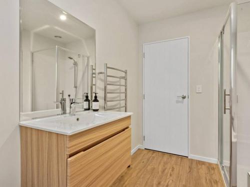 a white bathroom with a sink and a shower at Dumblane View in Hanmer Springs