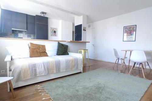 une chambre avec un lit, une table et des chaises dans l'établissement 2-pièces clair et calme, idéal Jeux Olympiques !, à Clichy