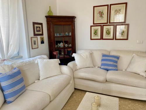 a living room with a white couch and blue pillows at Family House in Santa Severa