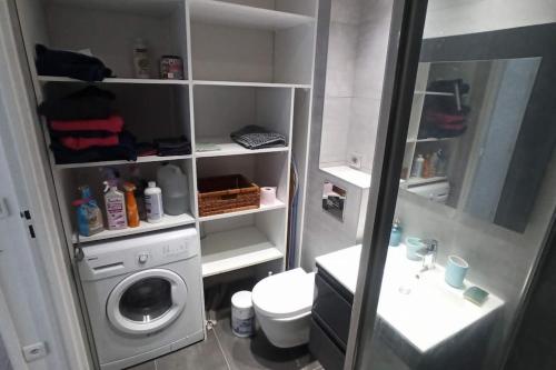 une salle de bain avec une machine à laver et un lave-linge dans l'établissement 2-pièces clair et calme, idéal Jeux Olympiques !, à Clichy