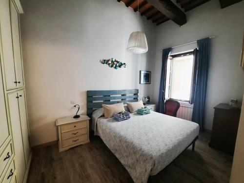 1 dormitorio con 1 cama, vestidor y ventana en La Casa degli Artisti, appartamento centralissimo, en Montepulciano