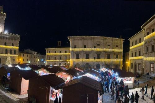 a group of people walking around a market at night at La Casa degli Artisti, appartamento in centro storico in Montepulciano
