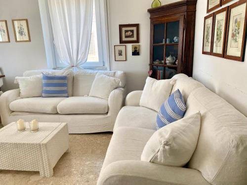 a living room with two white couches and a table at Family House in Santa Severa