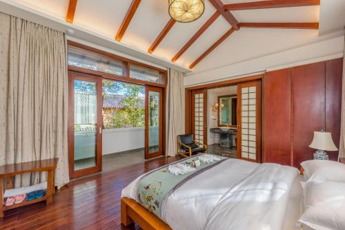 a bedroom with a large bed and a balcony at Leliving Butterfly Resort Lijiang in Lijiang