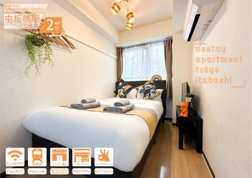 a bedroom with a bed with towels on it at nestay apartment tokyo itabashi in Tokyo