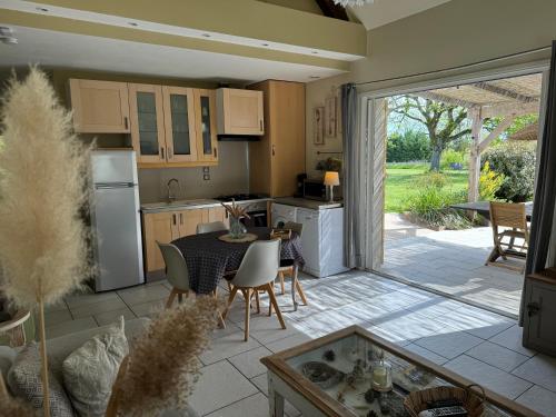 a kitchen and dining room with a table and chairs at Gîte de la Valière in Chevigny-en-Valière
