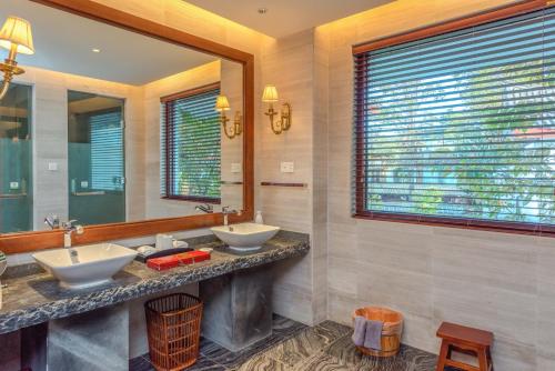 a bathroom with two sinks and a large mirror at Leliving Butterfly Resort Lijiang in Lijiang
