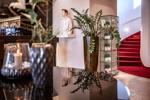 バート・ザウルガウにあるRomantik Hotel Kleber Postの花瓶と植物をテーブルに収めた部屋