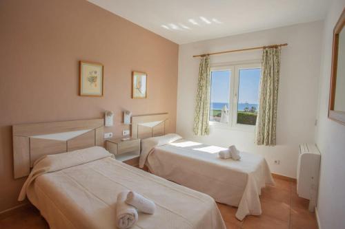 um quarto de hotel com duas camas e uma janela em Villa Primrosa - beautiful sea views em Son Bou