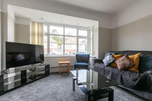 a living room with a couch and a flat screen tv at 3 bed family hse, Games Room, Parking, Garden in Kent