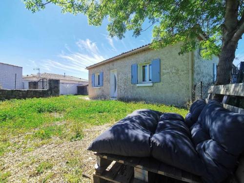 eine Couch in einem Garten vor einem Gebäude in der Unterkunft Maison O Volets Bleus Calme Jardin in Miramas