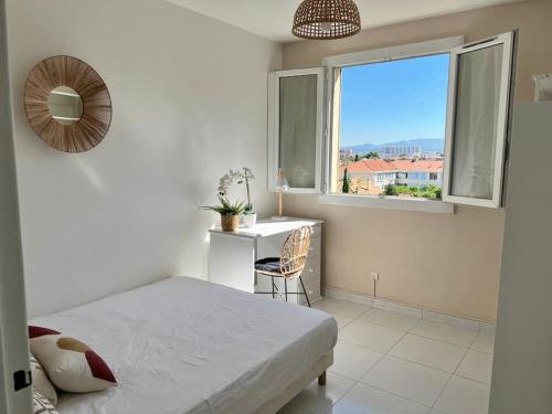 een slaapkamer met een bed, een bureau en een raam bij Appartement à 10 min de la plage - T4, 9ème in Marseille