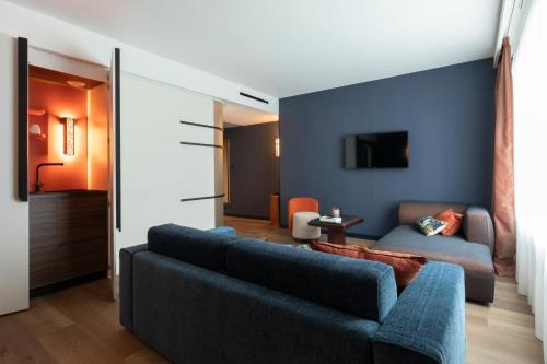 a living room with a couch and a tv at Hôtel & Spa Oceania Le Conti in Brest